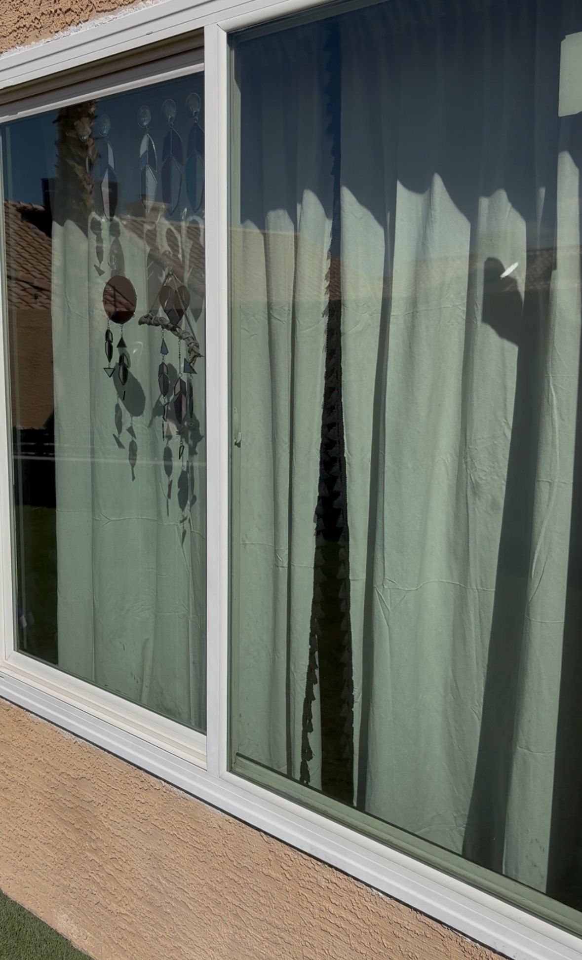 Cleaned sliding windows at a Las Vegas Valley home, with the curtains inside clearly visible through the glass