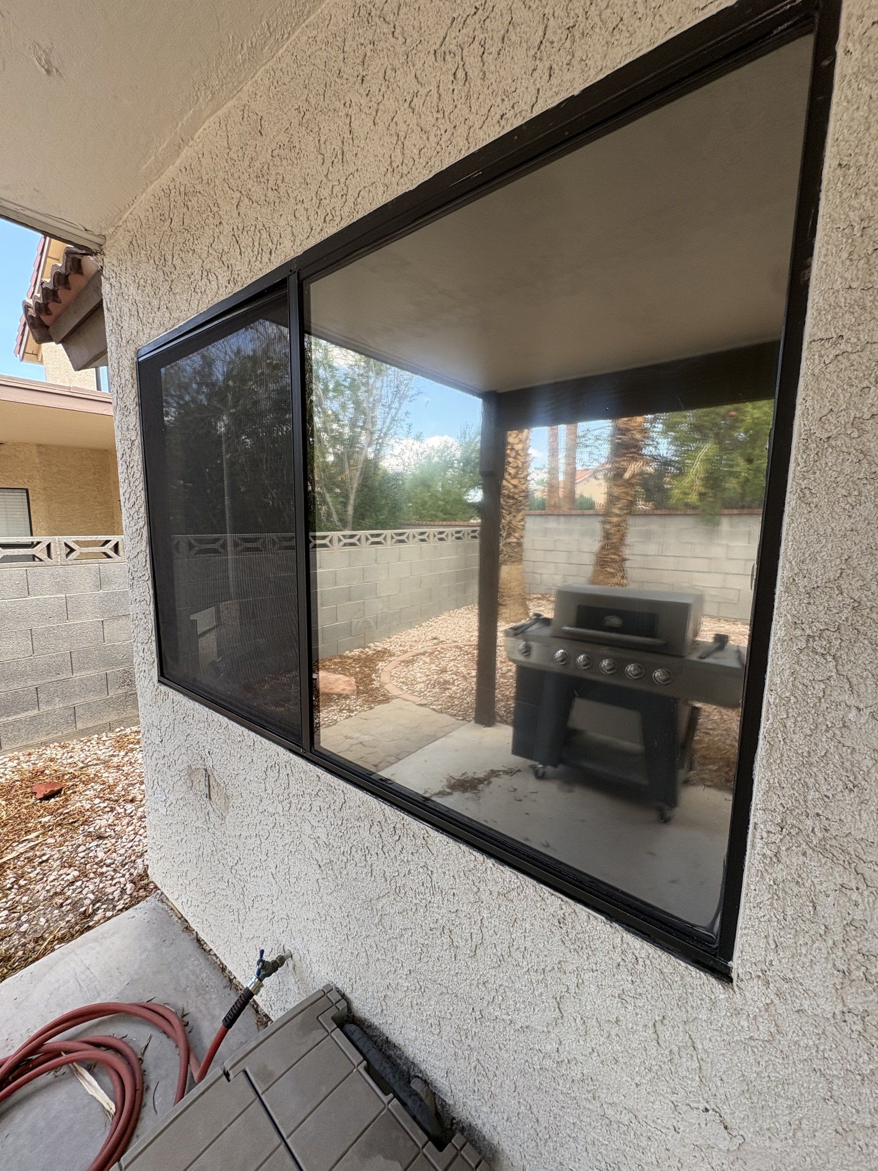 Cleaned picture window at a Las Vegas Valley home, reflecting the back yard and block wall